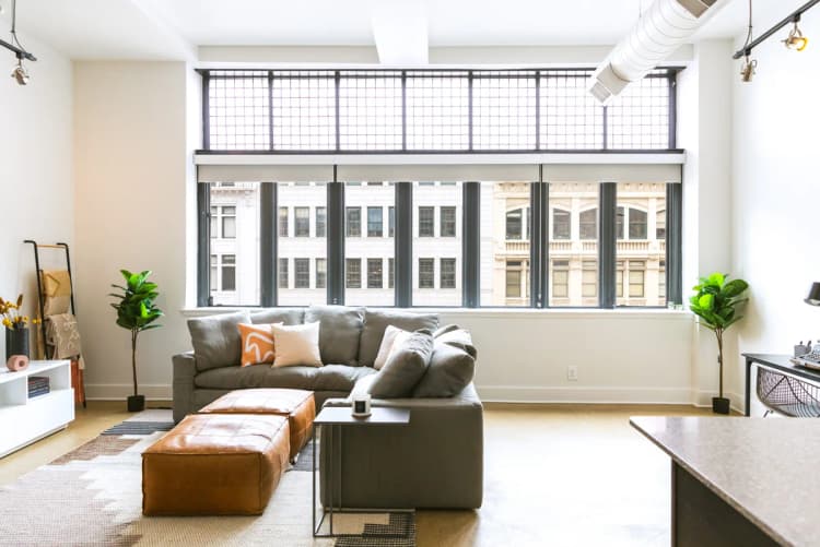 Detroit apartments for rent - image - a living room with a couch and a coffee table in front of a large window